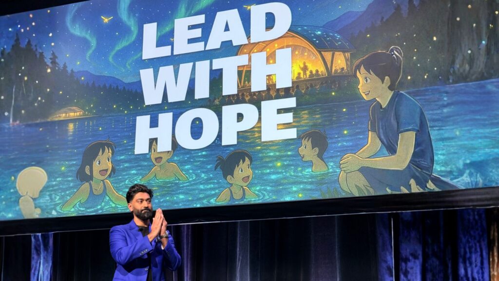 Hamza on stage sharing his keynote message at CPHR Alberta with a slide behind him that reads "Lead with Hope"
